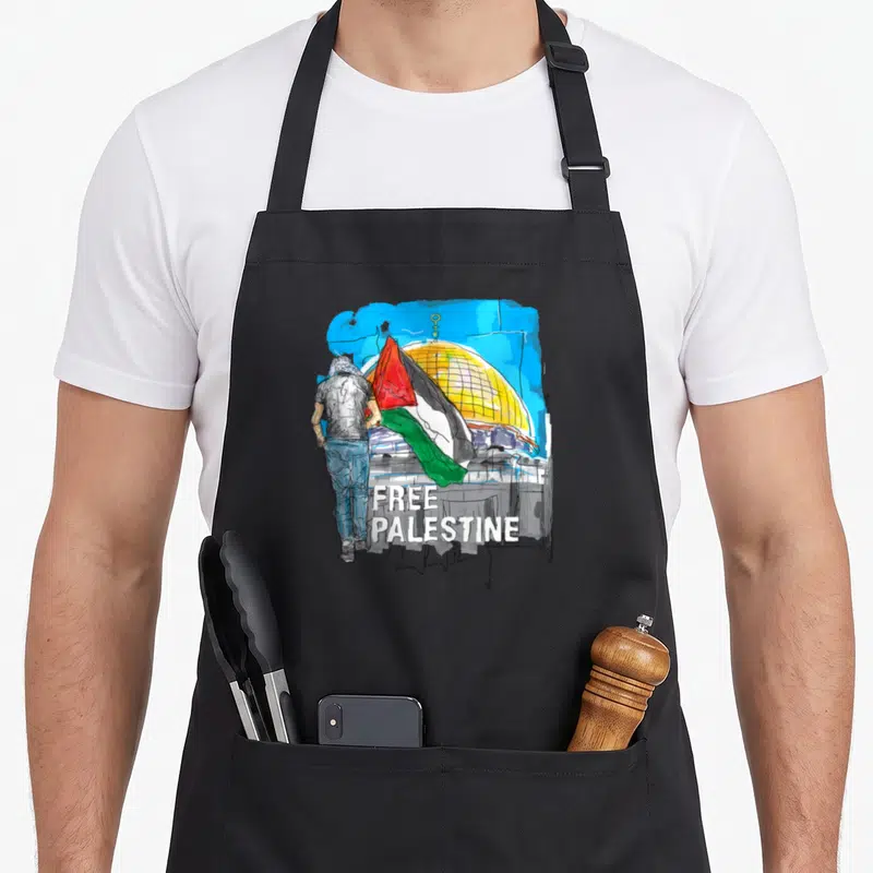 Tablier de cuisine noir avec illustration d'un homme regardant le dôme du Rocher sous un drapeau palestinien et le texte Free Palestine Save Gaza.