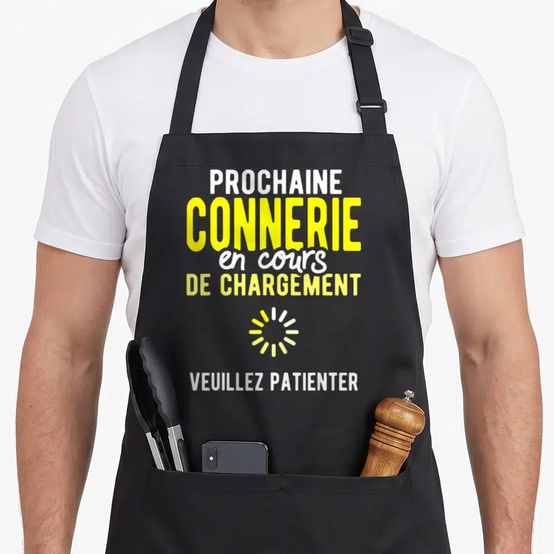 Tablier de cuisine noir avec le texte Prochaine connerie en cours de chargement et icône de chargement jaune.
