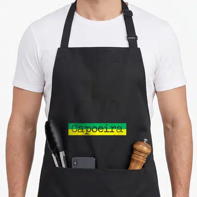 Tablier de cuisine noir avec silhouette capoeirista et texte Capoeira sur fond vert jaune