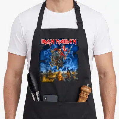 Tablier de cuisine noir avec l'illustration du Trooper d'Iron Maiden chevauchant un cheval squelettique sur fond bleu.