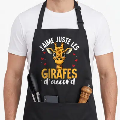 Tablier de cuisine noir avec une illustration de girafe souriante et des cœurs rouges autour du texte J'aime juste les girafes d'accord