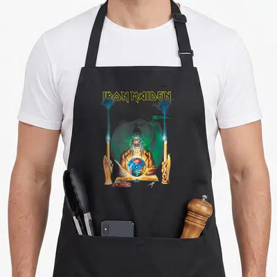 Tablier de cuisine noir avec illustration d'un homme aux cheveux blancs regardant une sphère cristalline encadrée par des bougies.