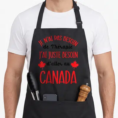 Tablier de cuisine noir avec inscription rouge et noire sur le Canada et deux feuilles d'érable rouges latérales.