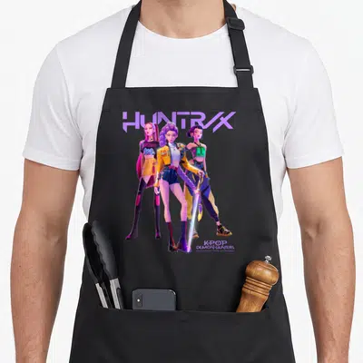Tablier de cuisine noir avec illustration colorée de trois personnages animés et une épée luminescente.