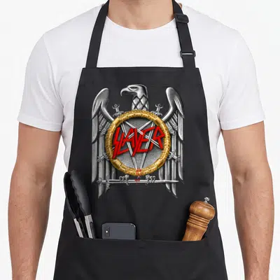 Tablier de cuisine noir avec un aigle argenté tenant des sabres autour d'un logo Slayer rouge dans un cercle doré.