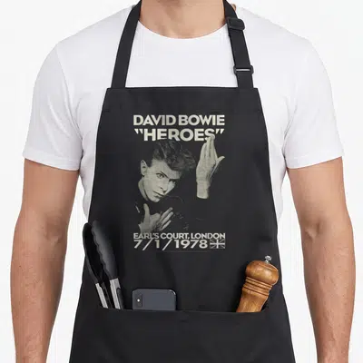 Tablier de cuisine noir avec portrait stylisé de David Bowie et le titre Heroes en typographie blanche vintage.