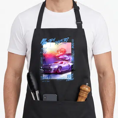 Tablier de cuisine noir avec illustration de voitures de course et texte graffiti coloré sur fond dégradé.