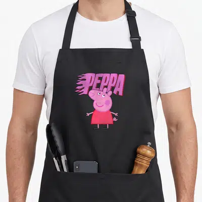 Tablier de cuisine noir avec Peppa Pig souriante et le mot PEPPA en lettres roses aux bords flamboyants.