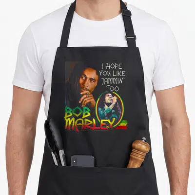 Tablier de cuisine noir avec illustration colorée de Bob Marley et texte blanc I hope you like jammin too.