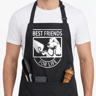 Tablier de cuisine noir avec illustration blanche d'un Cocker Spaniel et d'une poignée de main sous le texte Best Friends For Life.