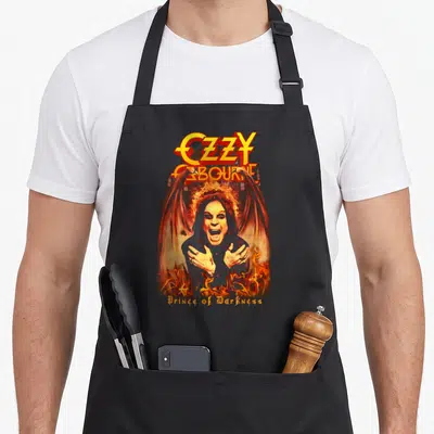 Tablier de cuisine noir avec illustration d'Ozzy Osbourne Prince of Darkness entouré de flammes et d'ailes de démon.
