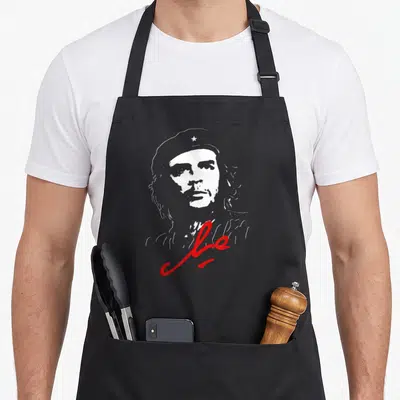 Tablier de cuisine noir avec portrait stylisé en blanc et signature rouge sous le menton.