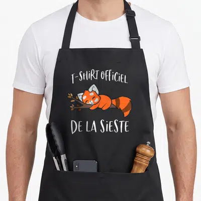 Tablier de cuisine noir avec un panda roux dormant sur une branche et du texte blanc.