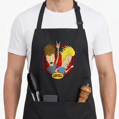 Tablier de cuisine noir avec illustration Beavis et Butt-Head au milieu de flammes rouges et d'un cercle.