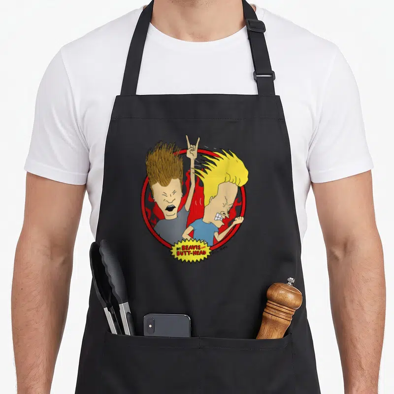 Tablier de cuisine noir avec illustration Beavis et Butt-Head au milieu de flammes rouges et d'un cercle.