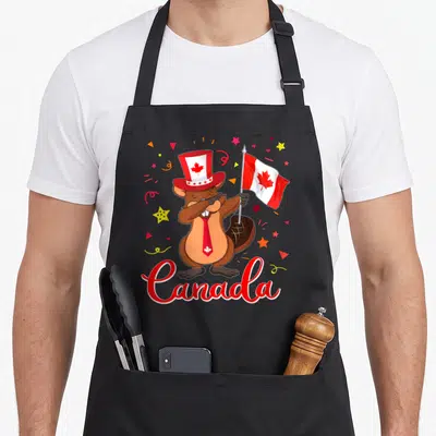 Tablier de cuisine noir avec un castor portant un chapeau à feuille d'érable et tenant le drapeau du Canada.