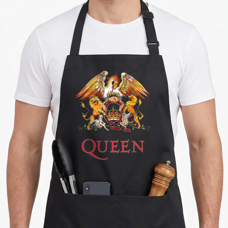 Tablier de cuisine noir avec un écusson coloré représentant un phénix, des lions et une lettre Q rouge en bas.