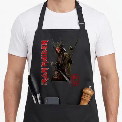 Tablier de cuisine noir avec illustration d'un samouraï démoniaque tenant un arc et une katana, flanqué du texte vertical Iron Maiden en rouge.