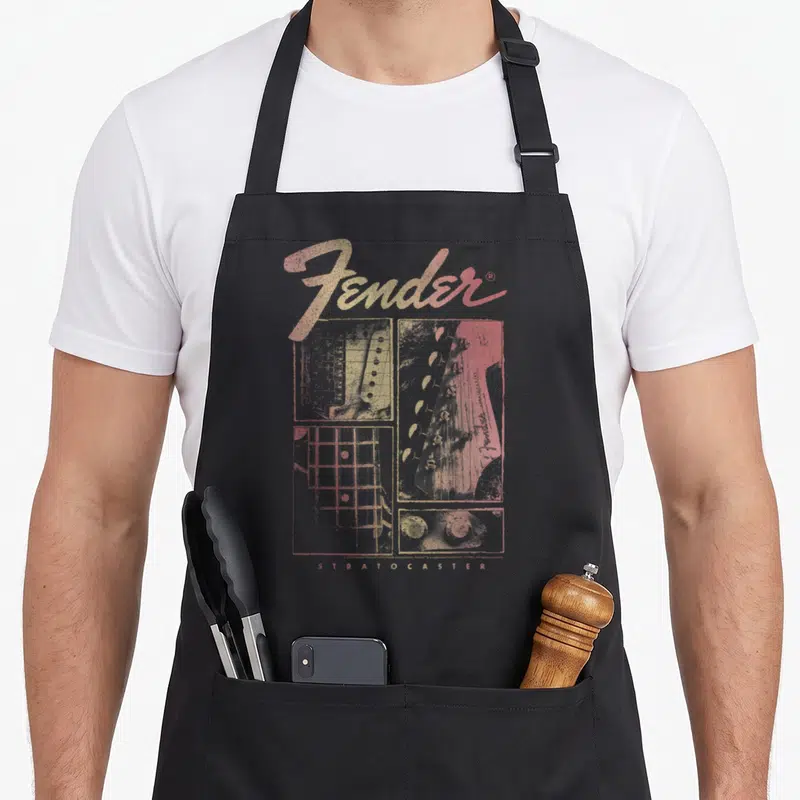 Tablier de cuisine noir avec illustration vintage Fender Stratocaster Panels en dégradé orange et jaune.