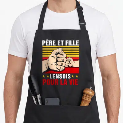 Tablier de cuisine noir avec illustration poings serrés père fille et texte Lensois Pour la vie en rouge et blanc.