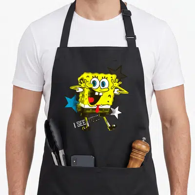 Tablier de cuisine noir avec Bob l'éponge jaune aux étoiles bleue et blanche et texte I SEE YOU en bas.