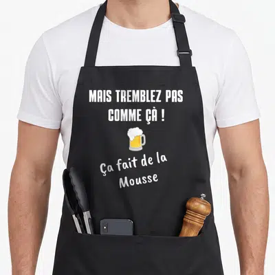 Tablier de cuisine noir avec inscription blanche et illustration de verre de bière à la mousse débordante.