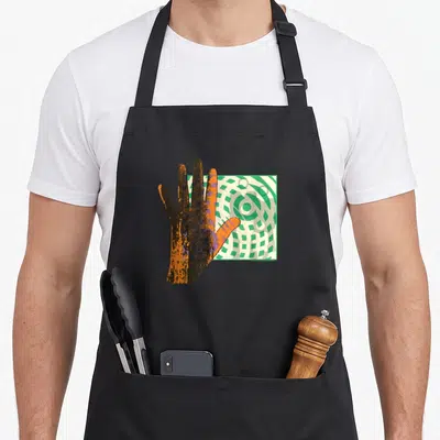 Tablier de cuisine noir avec une main orange stylisée devant un motif géométrique vert et blanc.