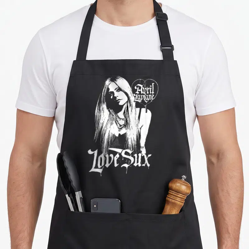 Tablier de cuisine noir avec illustration d'Avril Lavigne et texte Love Sux en blanc.