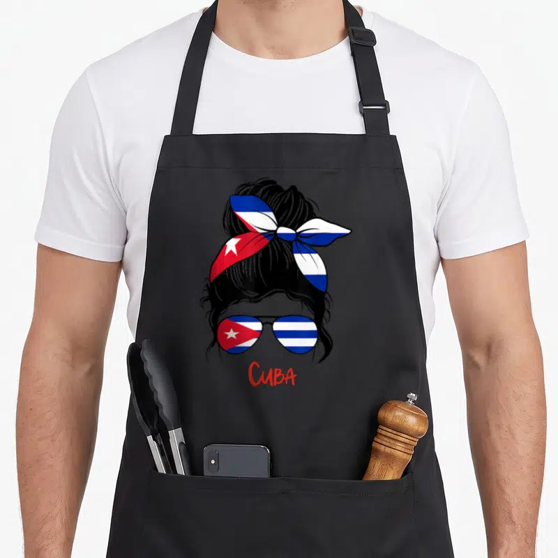 Tablier de cuisine noir avec une femme aux cheveux noirs portant un foulard et des lunettes aux couleurs du drapeau de Cuba.