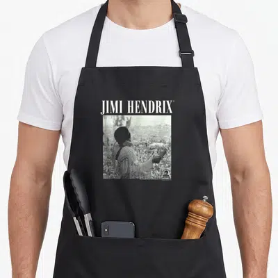 Tablier de cuisine noir avec Jimi Hendrix de dos et foule au Woodstock en noir et blanc.