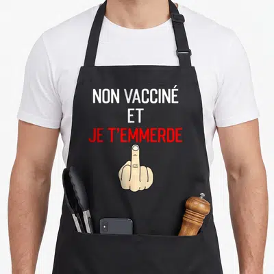 Tablier de cuisine noir avec le message Non vacciné et je t'emmerde en lettres blanches et rouges au-dessus d'une main.