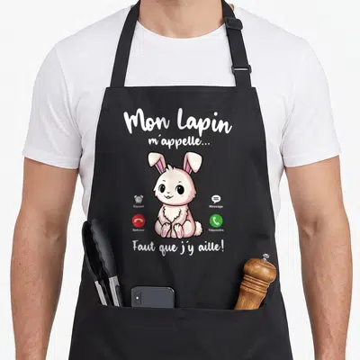Tablier de cuisine noir avec un lapin rose dessiné et les icônes d'un téléphone portable ainsi que du texte blanc.