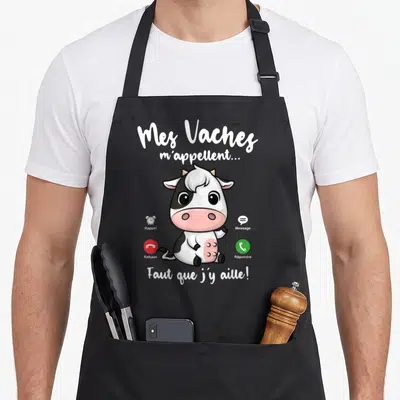 Tablier de cuisine noir avec une vache dessinée et les mots Mes Vaches m'appellent Faut que j'y aille.