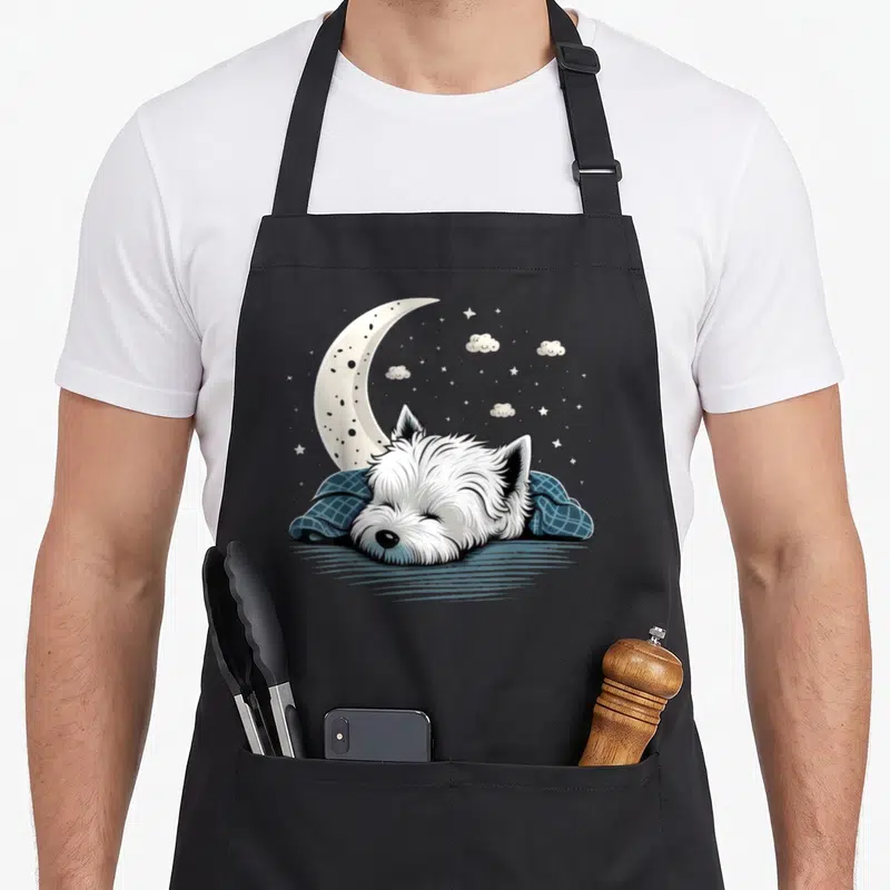 Tablier de cuisine noir avec illustration d'un Westie en pyjama dormant sous une lune croissante et des étoiles.