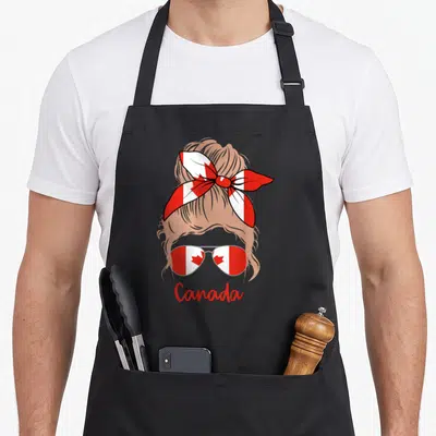 Tablier de cuisine noir avec illustration d'une fille blonde au foulard et lunettes à drapeau canadien