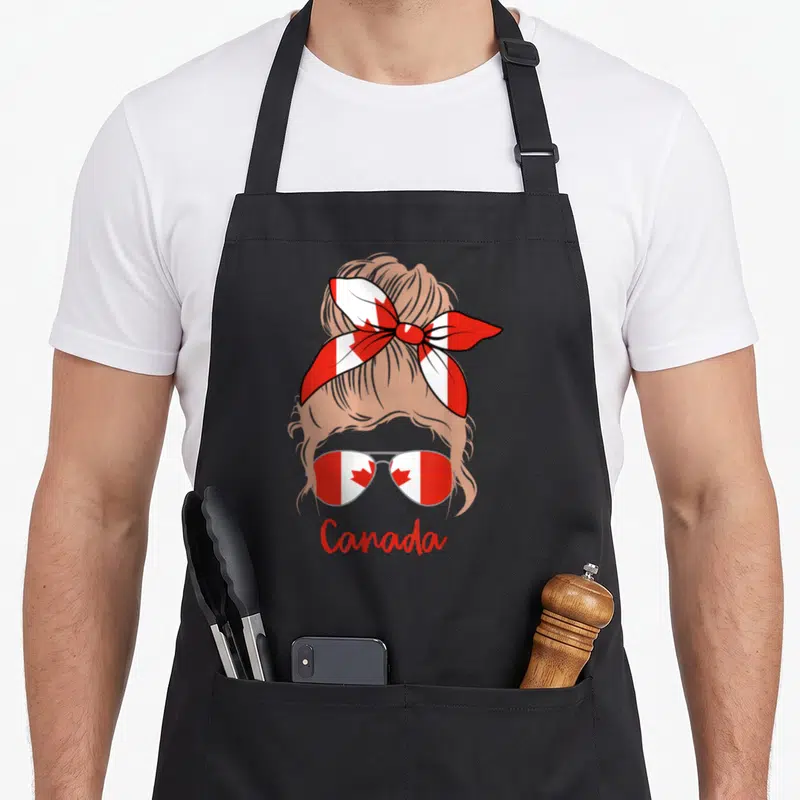 Tablier de cuisine noir avec illustration d'une fille blonde au foulard et lunettes à drapeau canadien