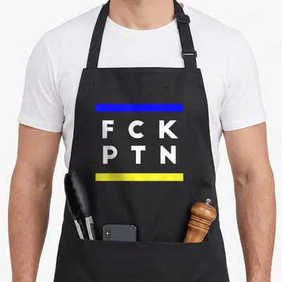 Tablier de cuisine noir avec inscription FCK PTN encadrée par des bandes bleue et jaune.