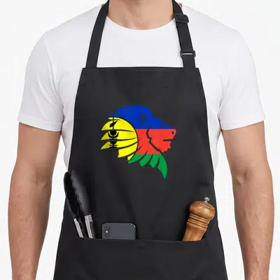 Tablier de cuisine noir avec un lion stylisé aux couleurs du drapeau calédonien, jaune, bleu, rouge et vert.
