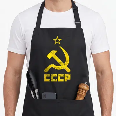 Tablier de cuisine noir avec CCCP jaune et étoile en haut du motif imprimé.