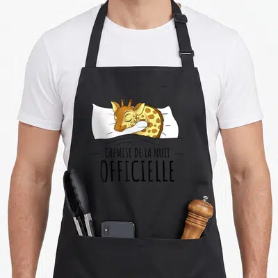 Tablier de cuisine noir avec une girafe dormant sur un oreiller et le texte « chemise de la nuit ».