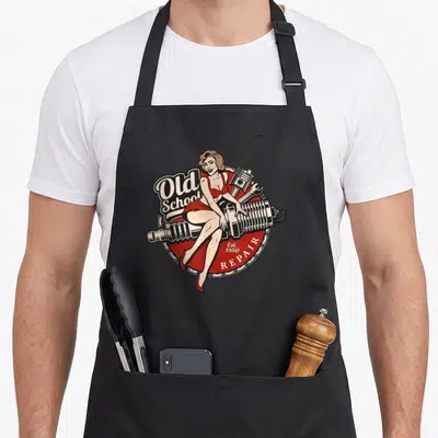 Tablier de cuisine noir avec illustration vintage pinup rouge sur moteur et texte Old School Repair.