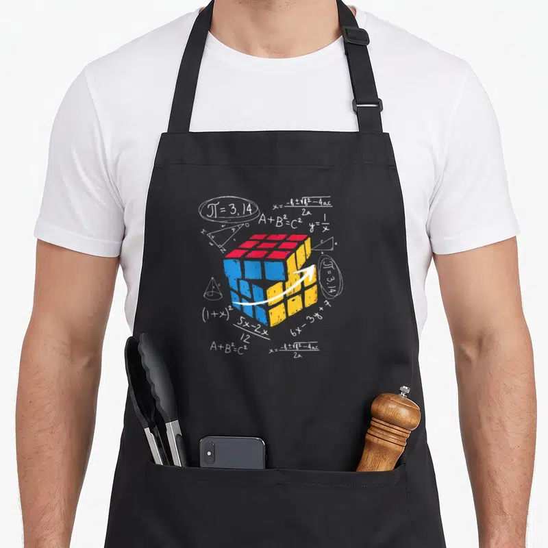 Tablier de cuisine noir avec un cube tridimensionnel coloré et des équations mathématiques blanches dispersées autour.