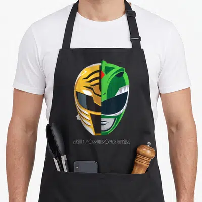 Tablier de cuisine noir avec illustration d'un casque Power Rangers moitié blanc moitié vert et texte en bas.