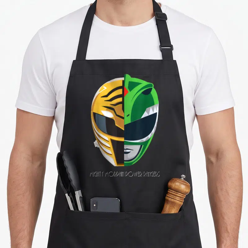 Tablier de cuisine noir avec illustration d'un casque Power Rangers moitié blanc moitié vert et texte en bas.