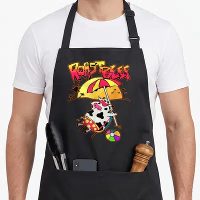 Tablier de cuisine noir avec une vache en lunettes de soleil sous un parapluie et le texte Roast Beef coloré.