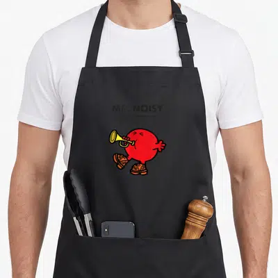 Tablier de cuisine noir avec illustration ronde de Mr. Noisy jouant d'une trompette dorée et portant des chaussures orange détaillées.