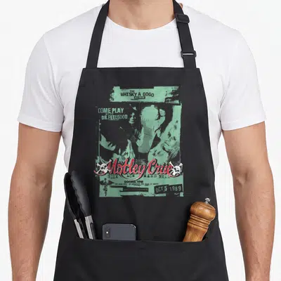 Tablier de cuisine noir avec une illustration verte et rouge représentant une affiche de concert de rock des années eighty.