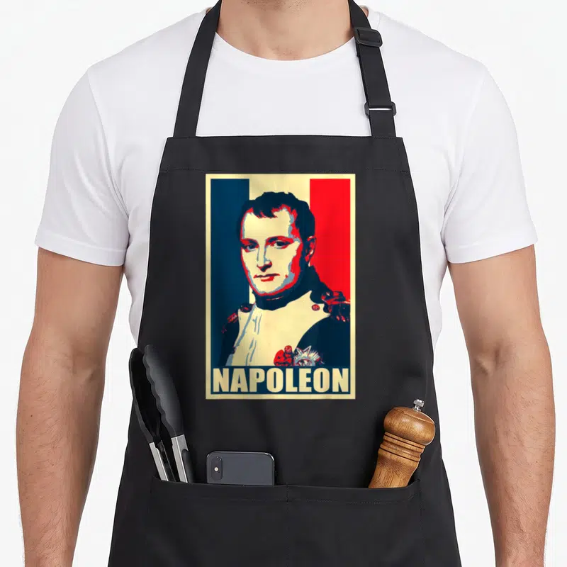 Tablier de cuisine noir avec portrait stylisé de Napoléon sur fond tricolore et le nom NAPOLEON en bas.