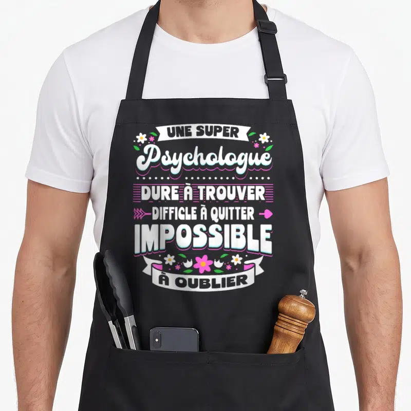 Tablier de cuisine noir avec inscription Une Super Psychologue Dure à Trouver Difficile à Quitter Impossible à Oublier entouré de fleurs roses et blanches.