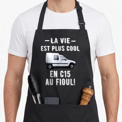 Tablier de cuisine noir avec illustration d'un fourgon blanc et texte blanc « la vie est plus cool en C15 au fioul »